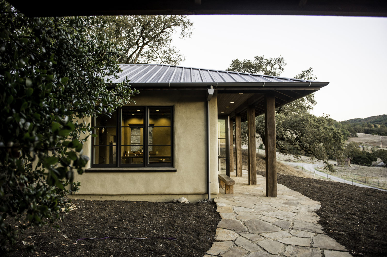 Aaron Grail natural-plaster home with metal roof on a Sonoma hillside